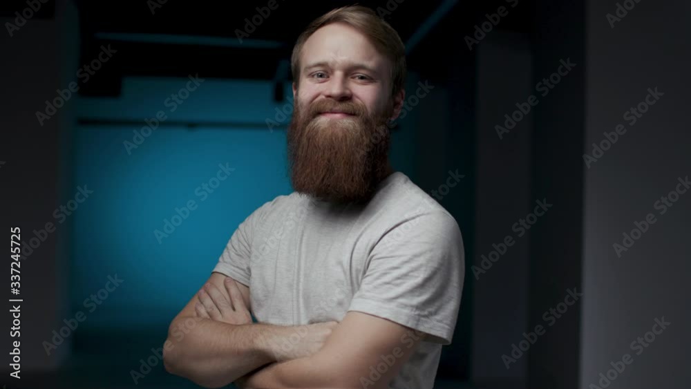 30s Youthful Handsome Man with Amazing Beard Turning Profile Face Straight to Camera and Smiling. Casual Close up View of Attractive Millennial Male Person Posing on Blue Background and Looking Glad 30s Youthful Handsome Man with Amazing Beard Turning Profile Face Straight to Camera and Smiling. Casual Close up View of Attractive Millennial Male Person Posing on Blue Background and Looking Glad