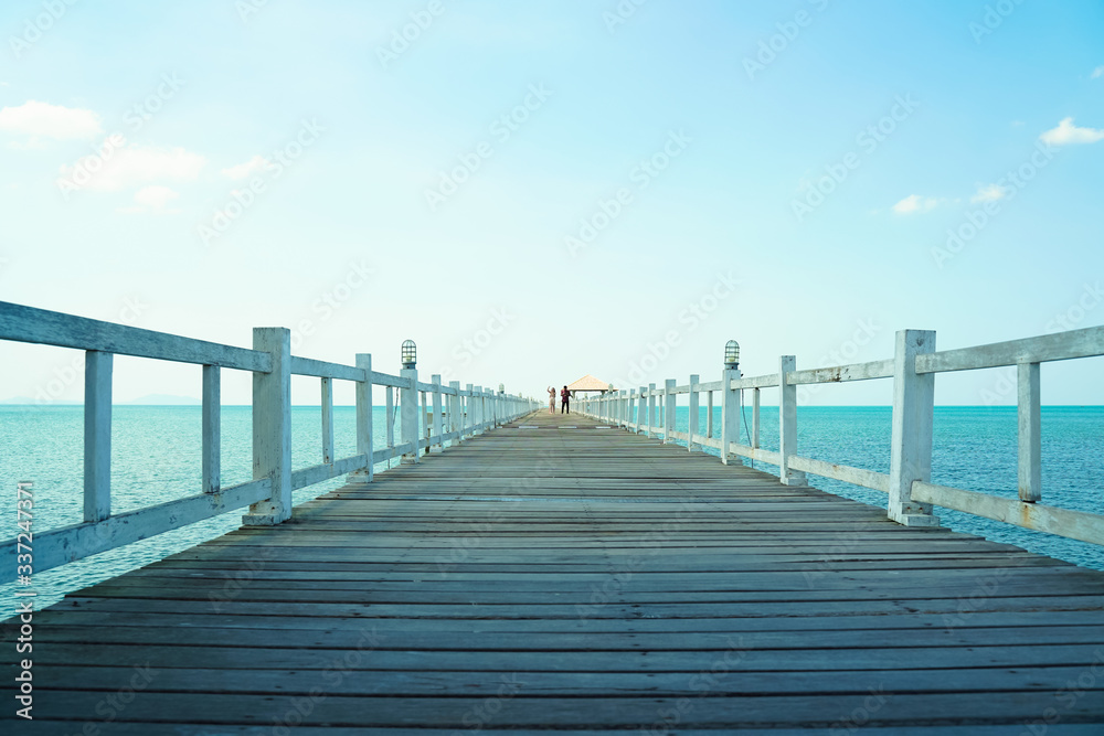 White wooden bridge stretching to the sea in sunny day.Feeling  freedom  with love.