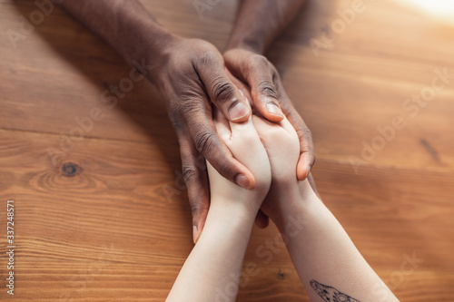 Love, family, support, friendship. Close up of african-american male and caucasian female hands holding. Concept of relationship, trust and confidence, helping hand, tenderness and warm. © master1305