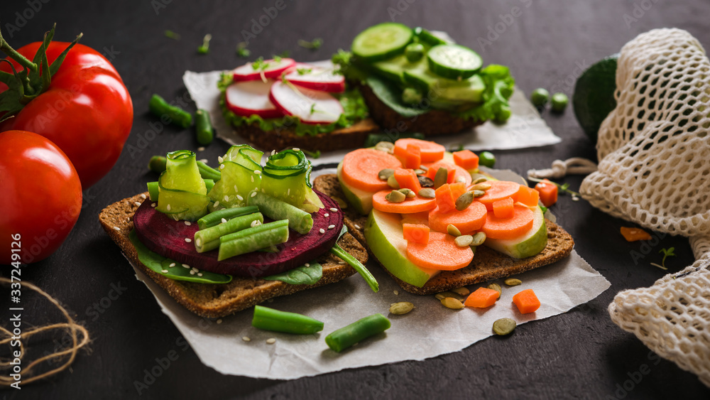 Set Vegetarian sandwiches, vegetables and fruits burger, healthy Breakfast on black concrete background,Vegan food.