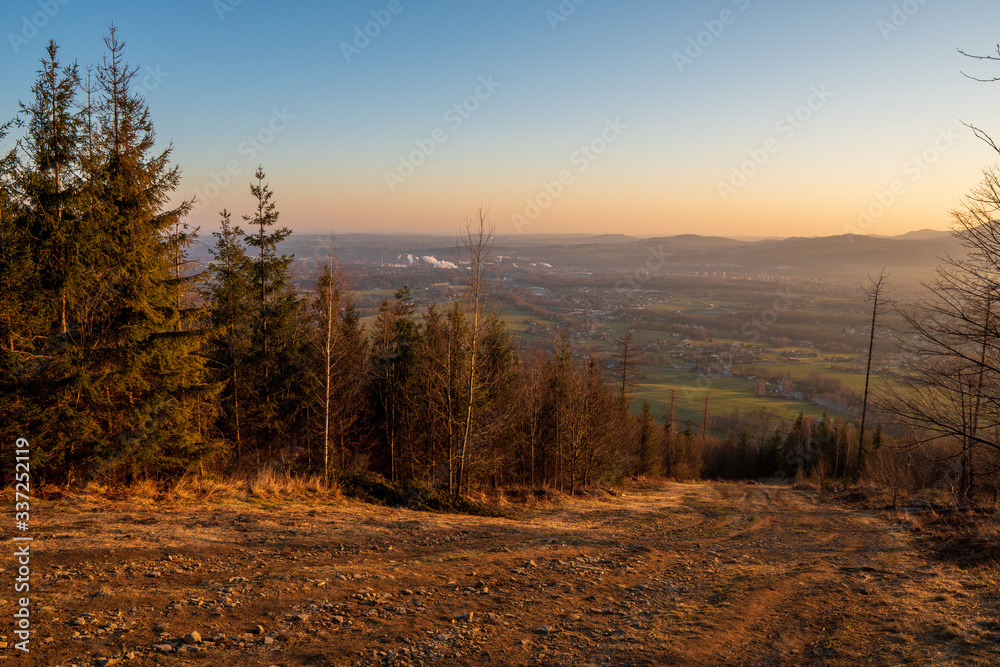 view of valley from hill at sunrise, houses and fields in countryside at sunrise, czech Beskydy Trinec