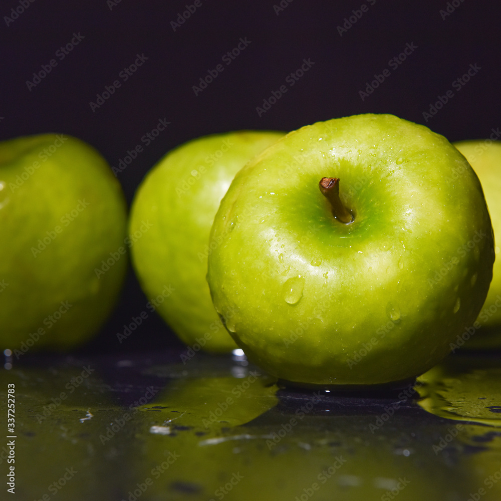 ripe green apples are covered with water drops