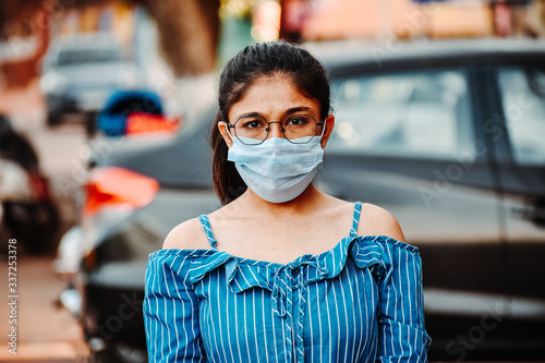 Portrait of an Indian female wearing medical mask to prevent herself from the Corona Virus Pandemic 