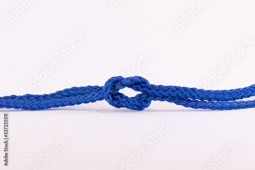 Blue string twisted and knotted against a white background