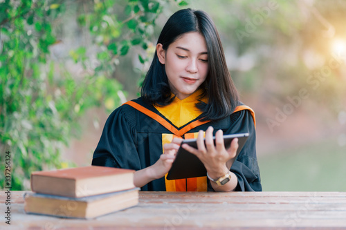 Young charming Asian feemale gradutes cerebrate her degree graduation after accomplish diploma certificate in commencement day. Congratulations on Education achievement photo