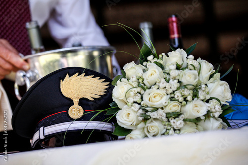 Cappello dei carabinieri vicino a Bouquet di fiori ad indicare il matrimonio. photo