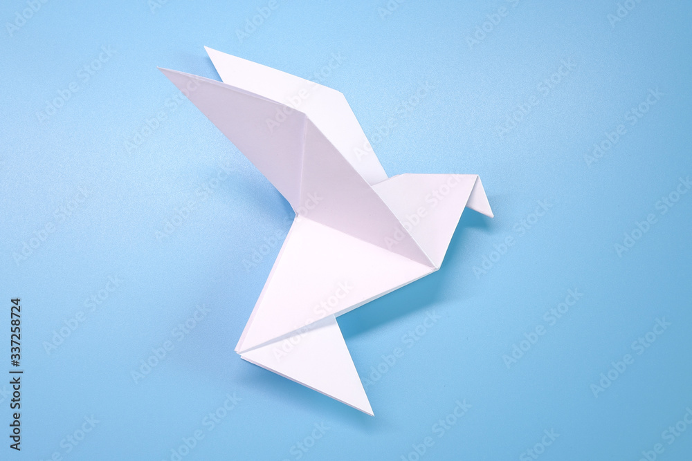 Fototapeta premium Origami : Flying dove on blue background. Concepts photo for help fight against COVID-19 campaign, symbol of peaceful
