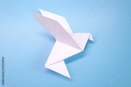 Origami : Flying dove on blue background. Concepts photo for help fight against COVID-19 campaign, symbol of peaceful