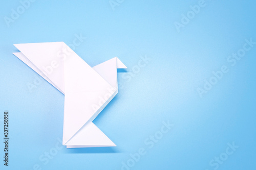 Origami : Flying dove on blue background. Selective focus with copy space. Concepts photo for help fight against COVID-19 campaign, symbol of peaceful