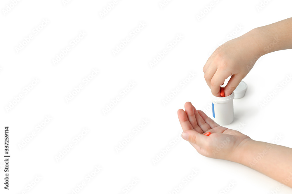 child takes pills without asking, orange capsules in the hands of children on a white background child takes pills without asking, orange capsules in the hands of children on a white background
