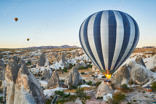 Hot air balloon flying low over the rocks in Cappadocia