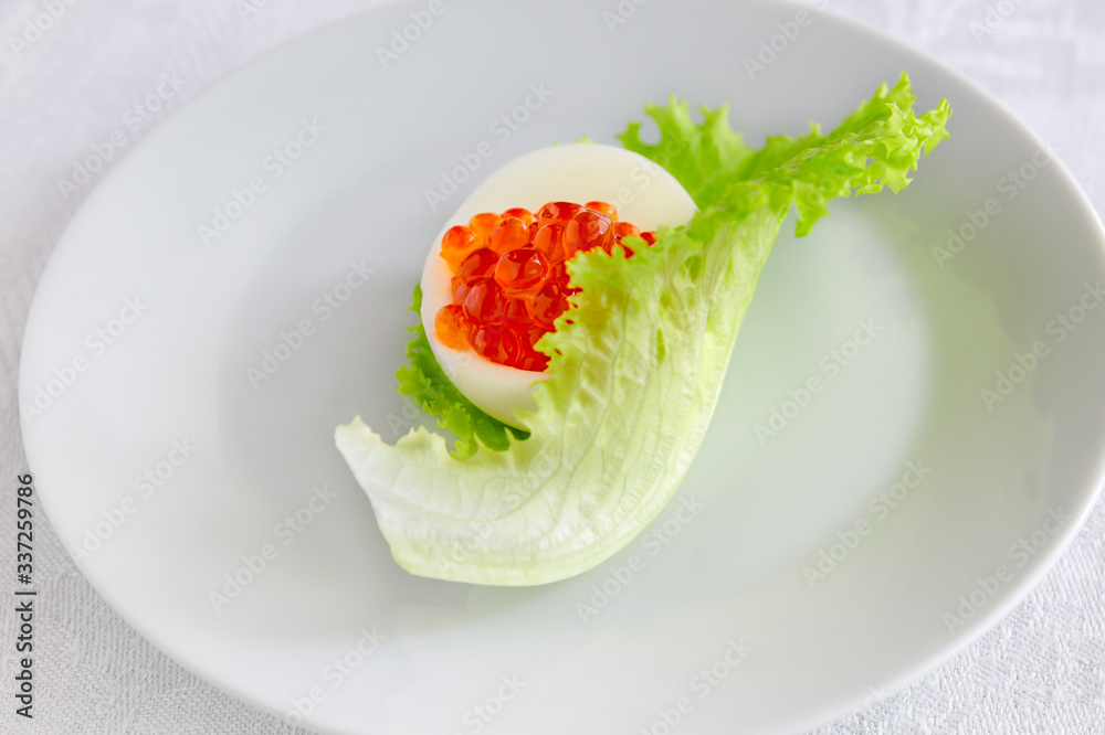 egg half with red caviar in iceberg lettuce leaf egg half with red caviar in iceberg lettuce leaf