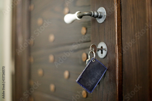 porta in legno di una camera d'albergo con chiave nella toppa photo