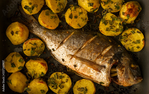 fish roasted with potato in a tray