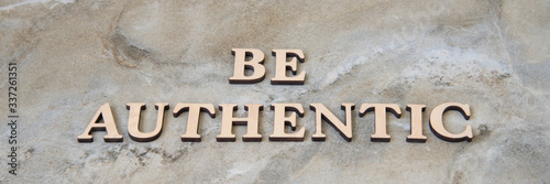 be authentic , writen wooden letters on stone background