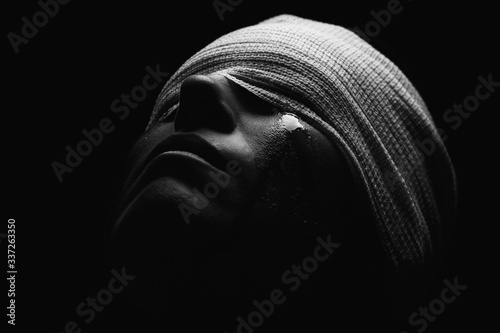 Fotografering Conceptual photo of a hurt woman crying with bandage around her head artistic co