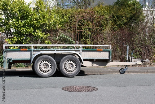 Zweiachsiger PKW-Anhänger aus Metall parkend an der Straße