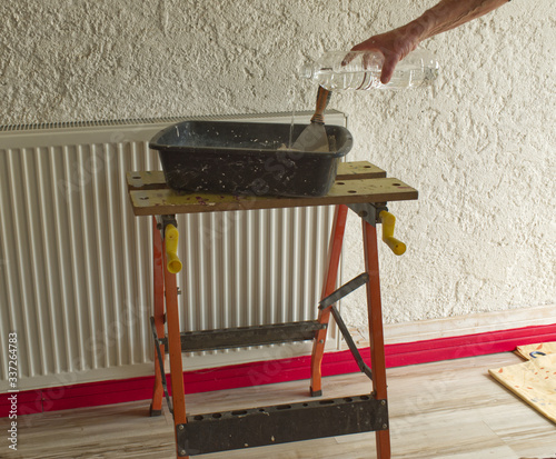 Foto Dépose d'enduit, de plâtre sur un mur par un plâtrier et préparation du mélange