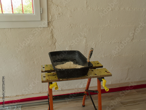 Bild auf Leinwand Dépose d'enduit, de plâtre sur un mur par un plâtrier et préparation du mélange