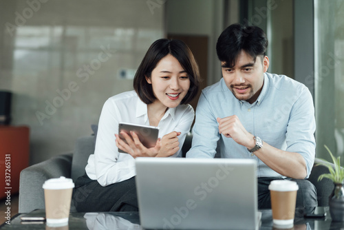 Two young Asian business men and women are working