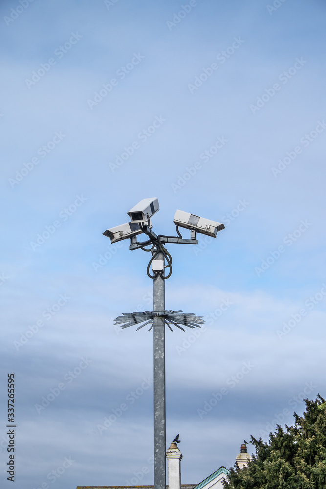 Security cameras with sky and roofs in England, UK