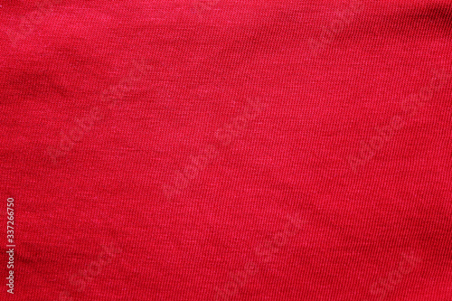 Red fabric texture background, empty cotton red cloth wallpaper. Soft textile material, close up top view of simple wavy t-shirt structure, fashion clothes plain unprinted design