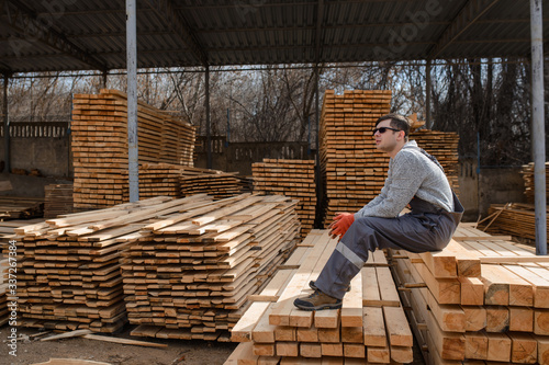 Portrait of young man carpenter at the wooden warehouse is resting © Med Photo Studio