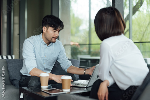 Two young Asian business men and women are working