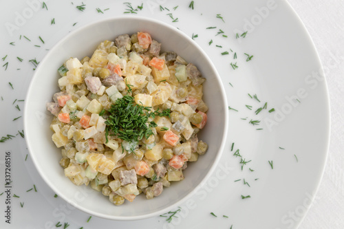 Obraz na płótnie russian salad dressed with mayonnaise and decorated with  dill