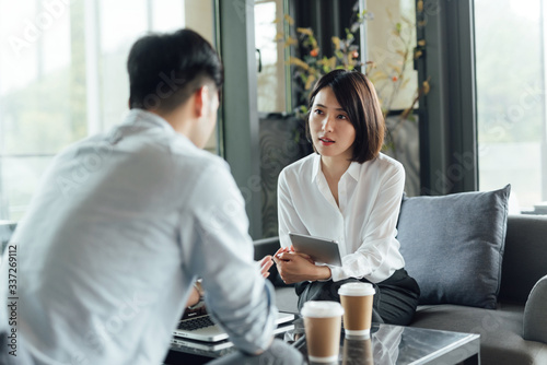 Two young Asian business men and women are working