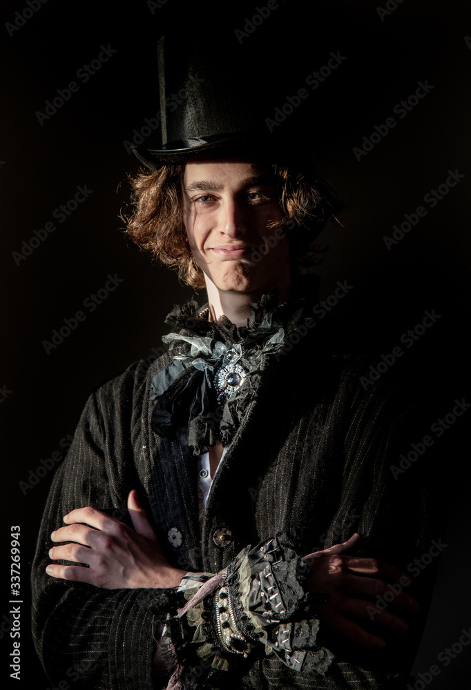 The young man in a top hat, tailcoat, lace. Portrait. Boho.