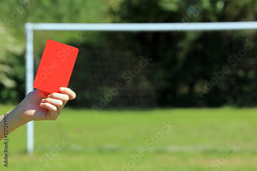 hand holding a soccer red card 