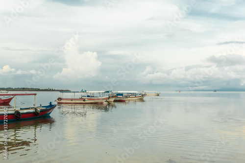 The boats are anchored without people. There are no tourists in Bali because of the Coronavirus. Landscape. Sea background