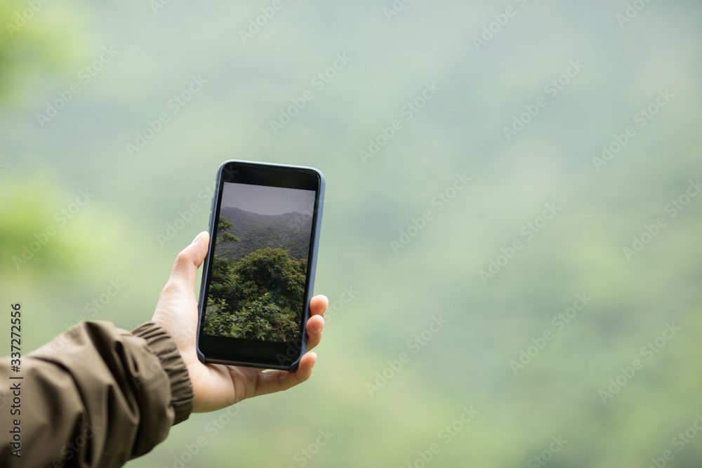Hiker hands taking picture with mobile phone in spring nature