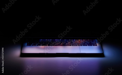 Laptop with Touchbar on dark background, color light photo