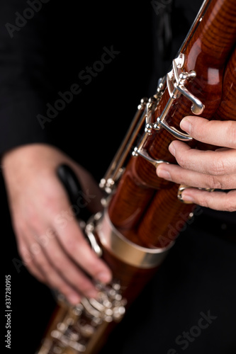 Wooden bassoon isolated on a black background. Musical instruments. Musician playing the instrument. photo