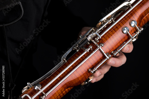 Wooden bassoon isolated on a black background. Musical instruments. Musician playing the instrument.