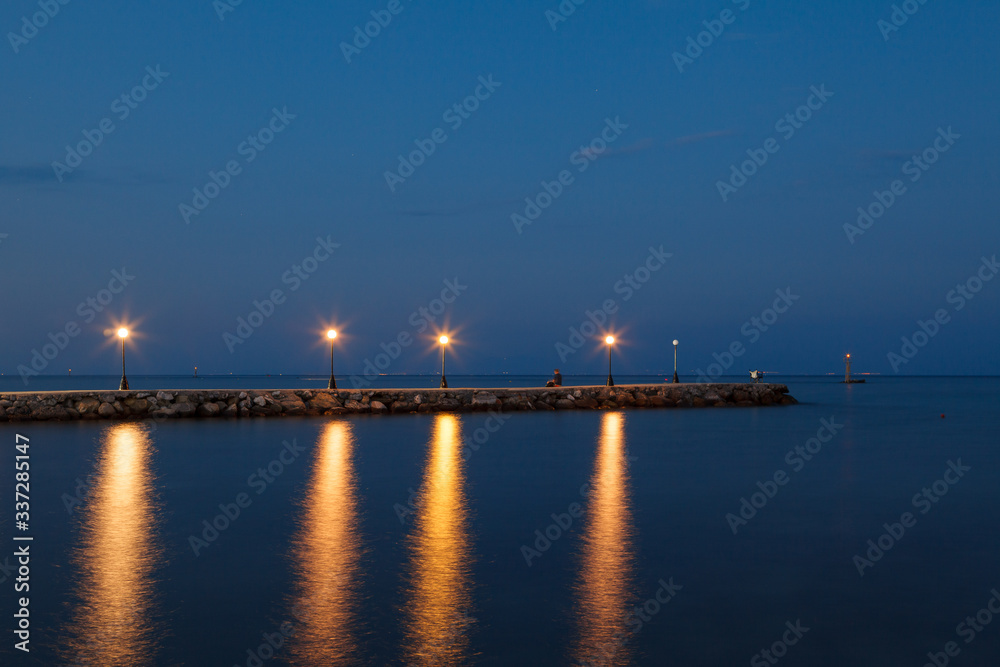 Paralia seaside promenade with lanterns, buildings and lighthouses in the port