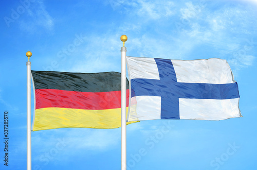Germany and Finland two flags on flagpoles and blue cloudy sky