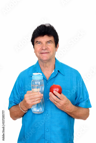 Portrait of happy mature handsome man holding bottle of water and apple