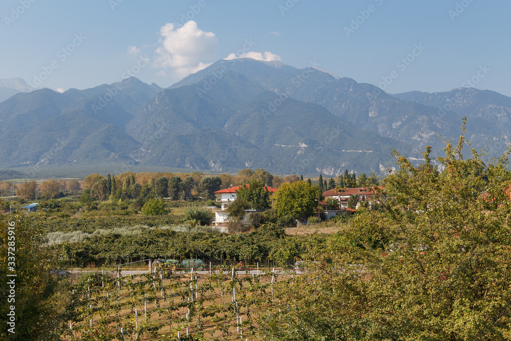 Traditional greek farms view with mountains at the background