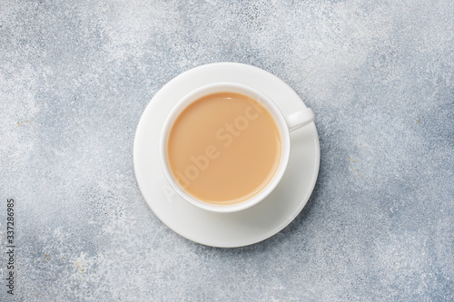 A Cup of coffee with milk in the center of the table. Top view.