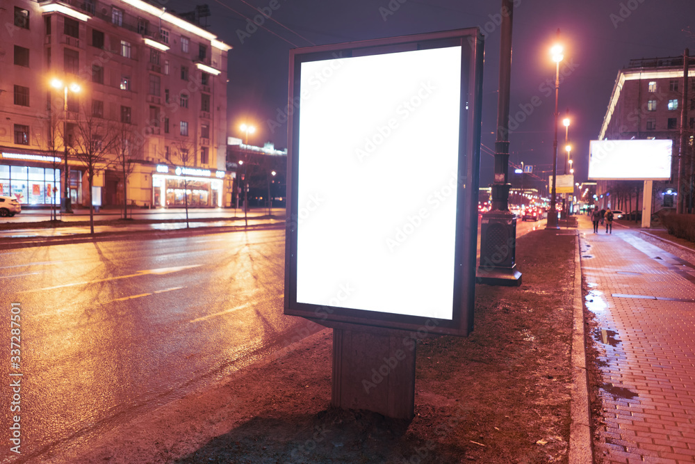 vertical billboard on the edge of the road at night