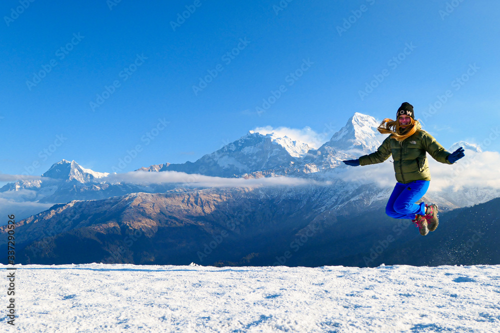 Girl is jumping in front of the mountains. White clouds. Green forest. Girl is jumping in front of the mountains. White clouds. Green forest.