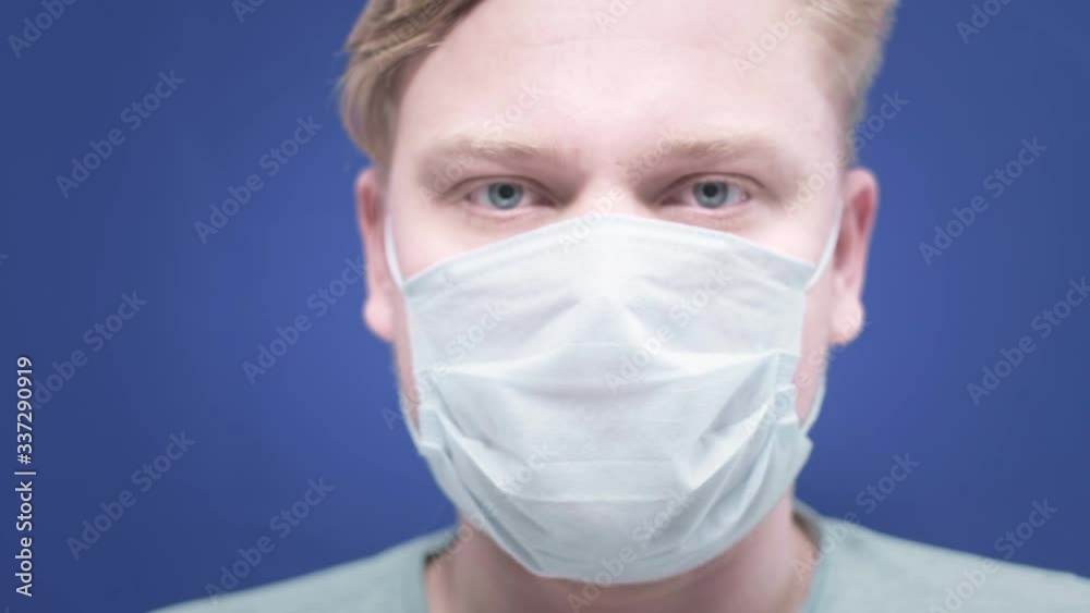 portrait of a young man putting a medical mask on his face. Concept of health and safety life, N1H1 coronavirus, virus protection, pandemic in china