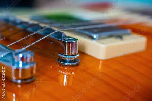 Close up of an electric guitar chromed bridge and strings