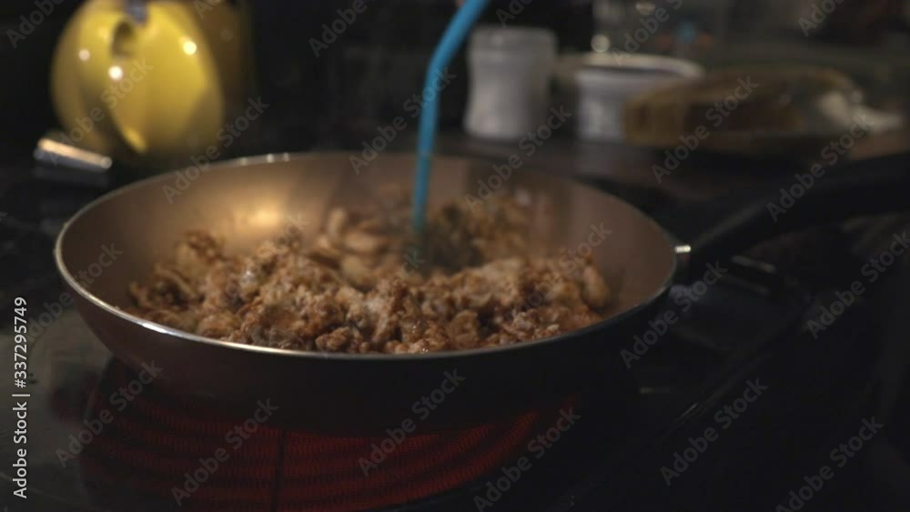 Cooking Meats In The Pan And Mixing It With A Slotted Turner In The Kitchen. -close up shot Cooking Meats In The Pan And Mixing It With A Slotted Turner In The Kitchen. -close up shot