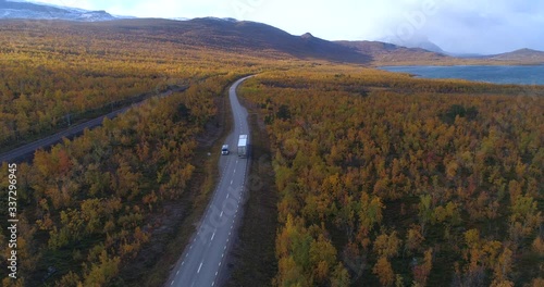 Aerial, drone shot, of a truck driving in polar wilderness, at lake Tornetrask and Abisko, asunny day, in Lappland, Norrbotten, Sweden photo