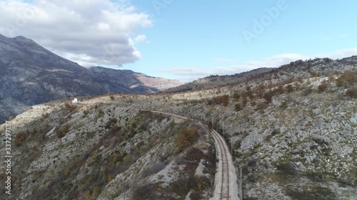Aerial footage - Railway high up in the Montenegro mountains. Sunny, bright day with blue sky and clouds. photo