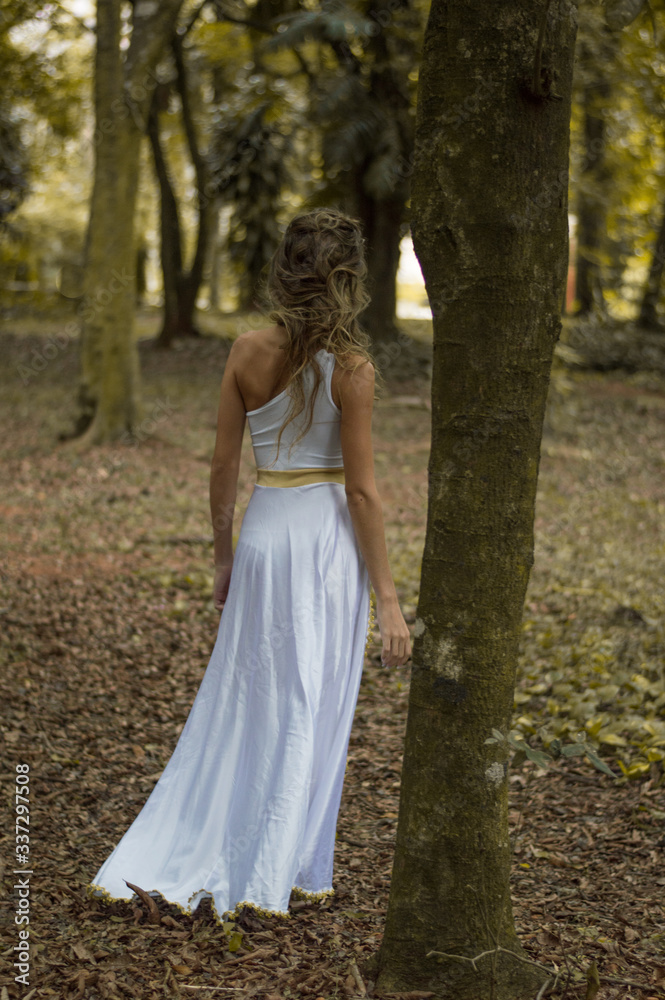 girl walking in the woods in a white dress